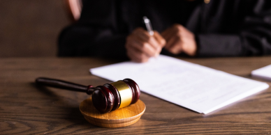 Image of a gavel and documents being signed.