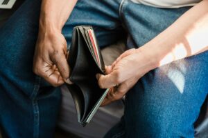 person opening empty wallet with no money no savings no cash broke accoutn